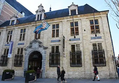 A yellow brick building with a blue roof