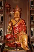 A statue of bodhisattva Kṣitigarbha holding a cintamani stone and a ring staff