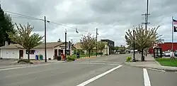 Photograph of an intersection in Lafayette, with the post office and city hall on either side.