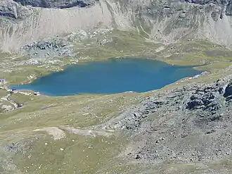 A body of water surrounded by green land.