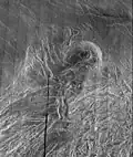 The radar smooth region in the northern part of the image is Lakshmi Planum, ringed by the intensely deformed terrain of Clotho Tessera.