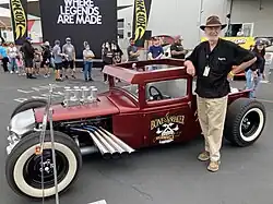 Larry Woods, Hot Wheels designer, posing next to a vintage car