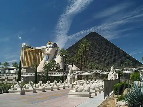 Luxor Hotel in Las Vegas with massive black glass pyramid, giant sphinx statue with blue and gold headdress, and rows of smaller sphinxes, all designed in Egyptian Revival style
