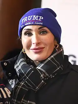 Head shot of Laura Loomer smiling at an event, wearing a MAGA beanie