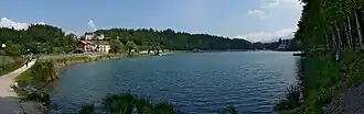 A body of water with greenery and houses in the distance.