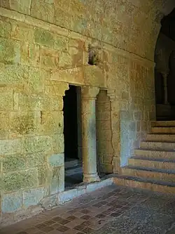 A stone wall with two openings divided by a pillar
