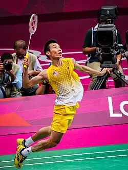 A man jumping and hitting a badminton birdie