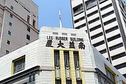 The Lee Rubber Building pediment still sports the original name, in English and Chinese