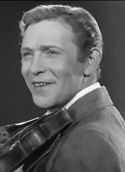 A black and white photo of Soviet singer Leonid Utyosov, smiling and looking to the left.