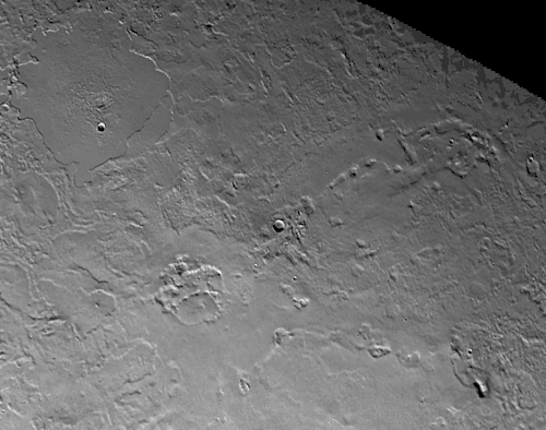 Close up of the volcanic province of Leviathan Patera, the caldera in the center of the image. Kraken Catena and Set Catena extend radially from the caldera to the right and upper-right of the image, while Ruach Planitia is seen to the upper left. Just off-screen to the lower left is a fault zone aligned radially with the caldera, indicating a close connection between the tectonics and volcanology of this geologic unit.