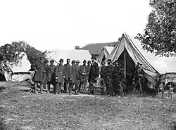 Lincoln among a group of soldiers in a military camp