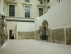 Wide view of Louvre gallery with lamassu and Assyrian reliefs
