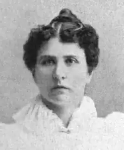 19th-century B&W portrait photo of a woman with her hair in an up-do, wearing a pale, fitted blouse.