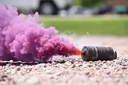 Smoke billowing from a violet M18 during Domestic Operations Training at Air National Guard base, Sioux City, Iowa, June 4, 2023.