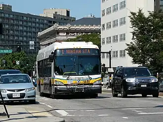 A white and yellow transit bus on an urban street