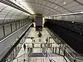 Picture of Macquarie University station. It consists of an underground platform with platform screen doors and a curved roof, similar to Macquarie Park station.
