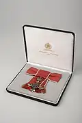 Photograph of the MBE medal awarded to Madeleine Sharp in 2002 in its presentation case.