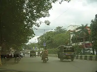 A divided road lined by 3-story shops