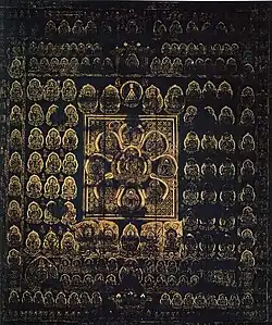 A large number of golden deities arranged in regular fashion on a dark-blue background. The deity in the center is surrounded by eight deities arranged like petals. These nine deities in flower-shape are surrounded by a square.