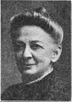 20th-century B&W portrait photo of an old woman wearing a dark blouse, her hair in an up-do