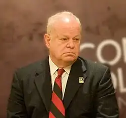 Photo of a man with grey hair and a black suit