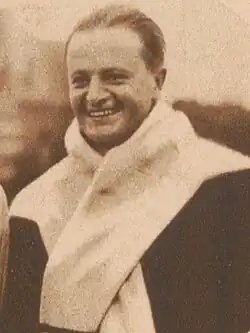 A sepia photograph of Maurice van den Bemden. He has a white towel draped around his neck.