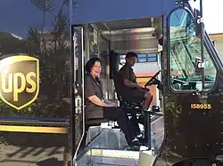 The UPS Driver Helper sits in a jump seat
