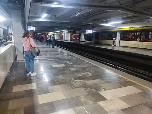 Multiple people wait for a train on the platforms.