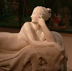 Detail from a sculpture showing a woman with her hair in a knot facing left
