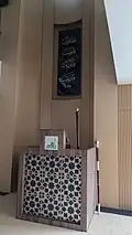 The wooden minbar of the mosque. A series of Qur'anic verses from Surah ash-Sharh can be seen mounted on the upper part of the mihrab.