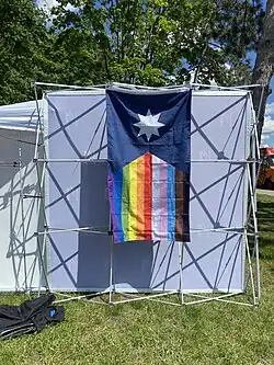 A Minnesota State Flag with a rainbow flag design on the field.