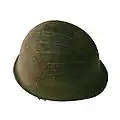 M1 helmet of the French Army on display as an ex-voto at Notre-Dame de la Garde in Marseille. The back of the helmet is slightly bent, suggesting that it was hit by a shrapnel and saved its owner.