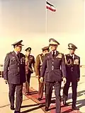 Shah Mohammad Reza Pahlavi speaking with army officials, flag visible in background, 1972