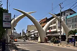 Picture of the four white tusks, in two pairs each forming an arch, over a dual carriageway