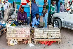 Image 7In 2014, a money changer in the capital, Hargeisa. Large stacks of banknotes are prepared due to inflation. (from History of Somaliland)