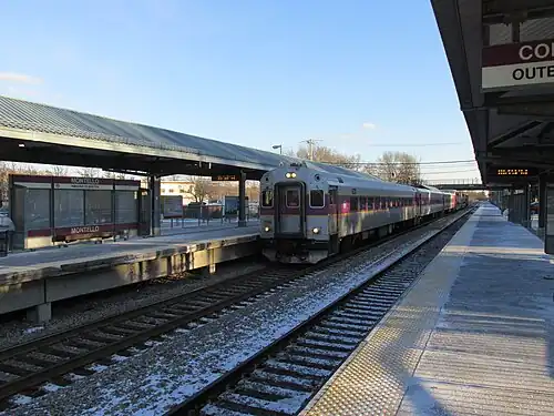 A passenger train arriving at a railway station with two high-level side platforms
