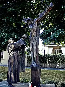 Sculpture of Padre Pio reaching toward Jesus on the cross, Prato, Italy