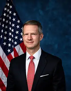 Official House portrait of Moore in front of the U.S. flag, wearing a black suit, white shirt, and red and white tie.