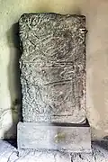 Morsleben Stone 1. Below, a lamb carries the cross. Above is a braided animal figure akin to that of the rider stone.