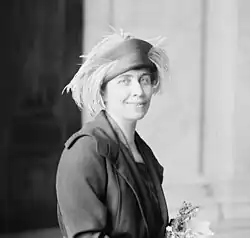 Image of Grace Coolidge knitting in 1921 smiling and elegantly sophisticated.