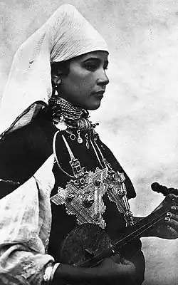 Image 34A Berber musician wearing two large triangular brooches in southern Morocco (early 20th century photo) (from Culture of Morocco)