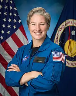 NASA astronaut Erin Overcash, a woman in a blue flight suit, smiles for official NASA portrait