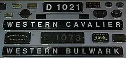 Rectalgular plates with black background and raised aluminium numbers and letters