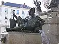 Bronze statue on a granite base; water gushes from an amphora