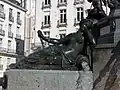 Bronze statue on a granite base; water gushes from an amphora