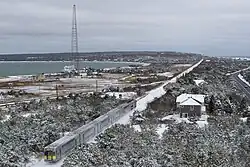 Aerial view of an eastbound LIRR passenger train passing Mackay Tower