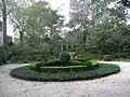 View of the gardens, ending in a small green lawn, surrounding the house