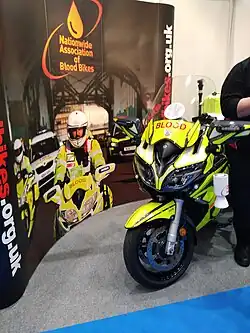 A yellow blood bike at an indoor information stand