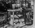 Photograph of Nell Shipman looking into the cage of a cougar