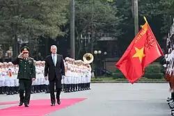 Vietnam People's Army Honor Guards hosting a ceremony to welcome U.S. SecDef Jim Mattis, featuring the force's war flag which is the Vietnamese flag defaced with the military's motto.